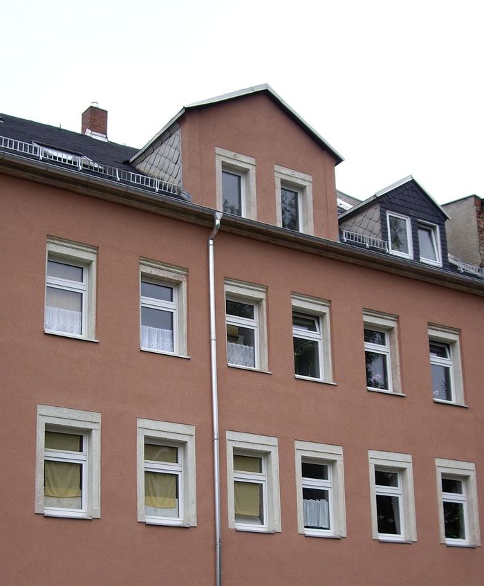 Maler- und Putzarbeiten an der Fassade eines Mehrfamilienhauses.